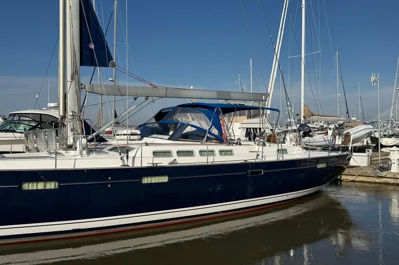 Slide: The Image of 2004 Beneteau 57 sailboat docked in marina under clear blue sky. - 2