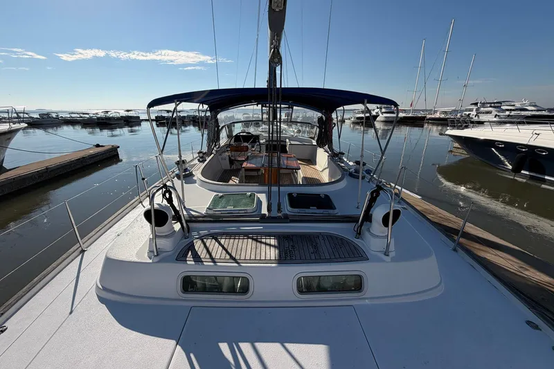 Slide: The Image of 2004 Beneteau 57 sailboat docked in a marina under clear blue skies. - 23