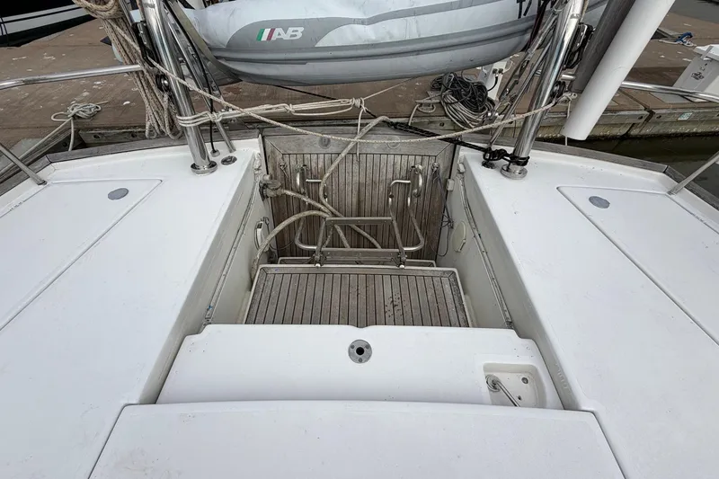 Slide: The Image of Stern view of 2004 Beneteau 57 yacht with wooden deck and dinghy. - 25
