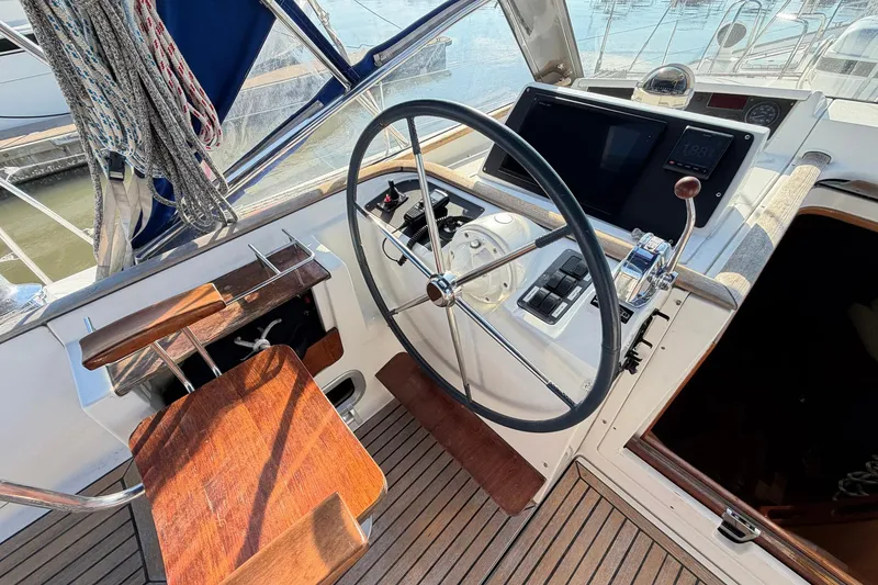 Slide: The Image of Cockpit of 2004 Beneteau 57 sailboat with steering wheel and navigation controls. - 31