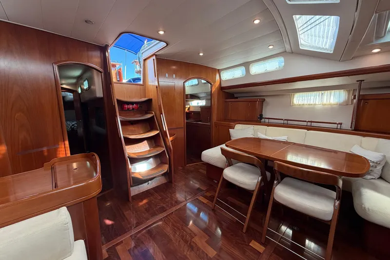 Slide: The Image of Luxurious interior of 2004 Beneteau 57 yacht with wooden finishes and elegant seating area. - 39