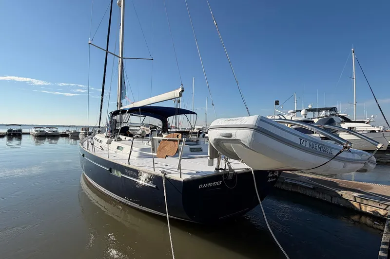 Slide: The Image of 2004 Beneteau 57 yacht docked at marina under clear blue sky. - 4
