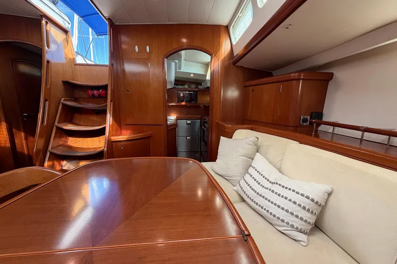 Slide: The Image of Luxurious interior of a 2004 Beneteau 57 yacht with wooden finishes and cozy seating. - 43