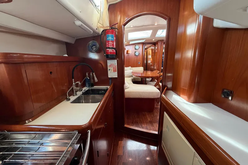 Slide: The Image of Luxurious interior of 2004 Beneteau 57 yacht with wood finish and cozy seating area. - 49
