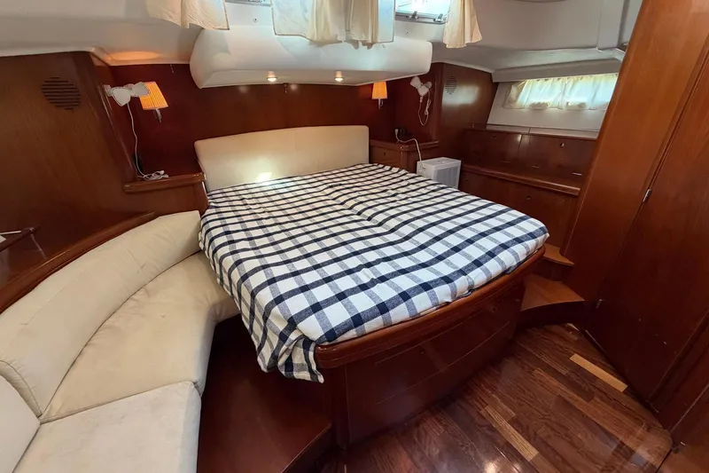 Slide: The Image of Luxurious cabin interior of 2004 Beneteau 57 yacht with cozy bed and elegant wood finish. - 53