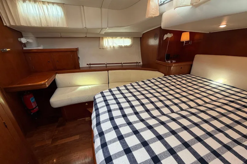 Slide: The Image of Luxurious cabin interior of a 2004 Beneteau 57 yacht with cozy seating and bed. - 55