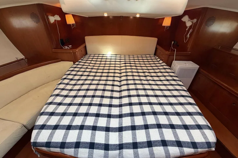 Slide: The Image of Luxurious cabin interior of a 2004 Beneteau 57 yacht with a checkered bedspread. - 57
