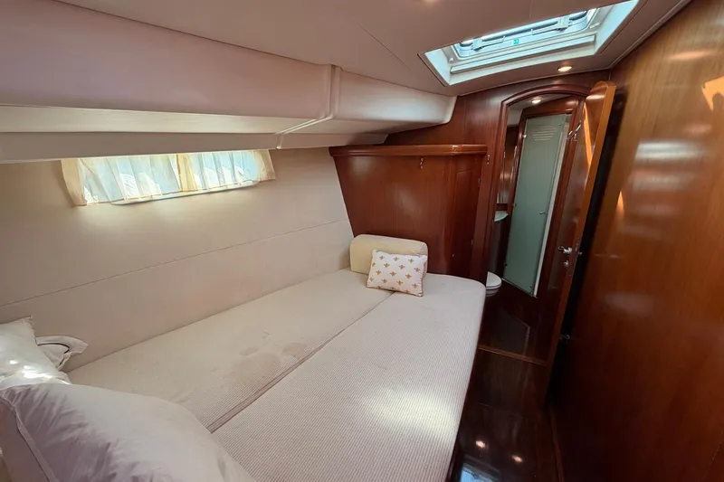 Slide: The Image of Luxurious cabin interior of 2004 Beneteau 57 yacht with cozy bed and wooden finish. - 64