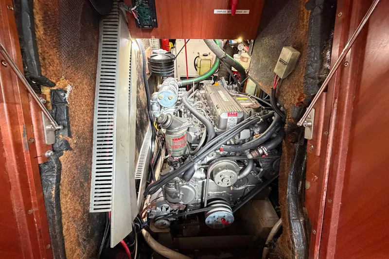 Slide: The Image of Engine compartment of a 2004 Beneteau 57 sailboat, featuring a Yanmar engine. - 77