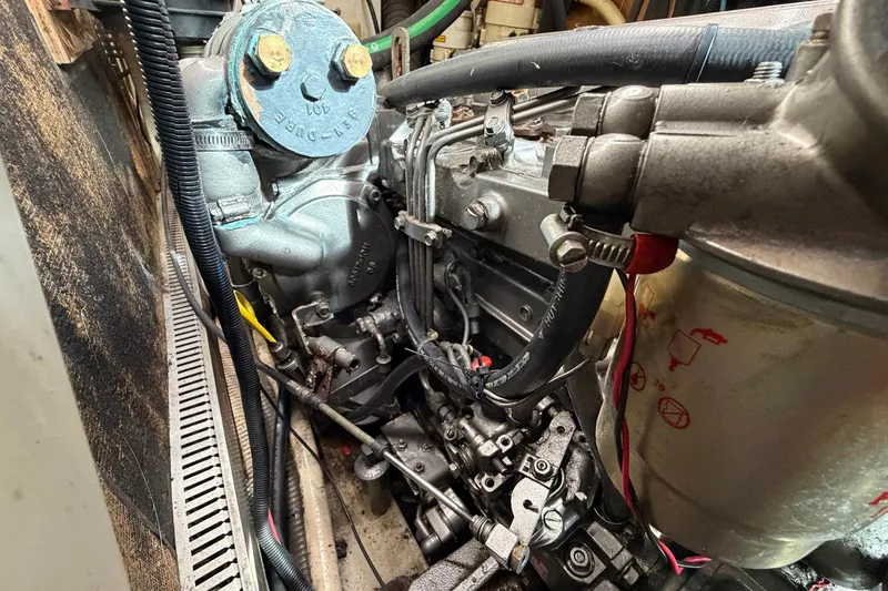 Slide: The Image of Engine compartment of a 2004 Beneteau 57 sailboat, showcasing mechanical components and hoses. - 78
