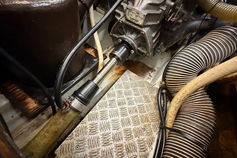 Slide: The Image of Engine compartment of a 2004 Beneteau 57 sailboat, showing mechanical components and hoses. - 80