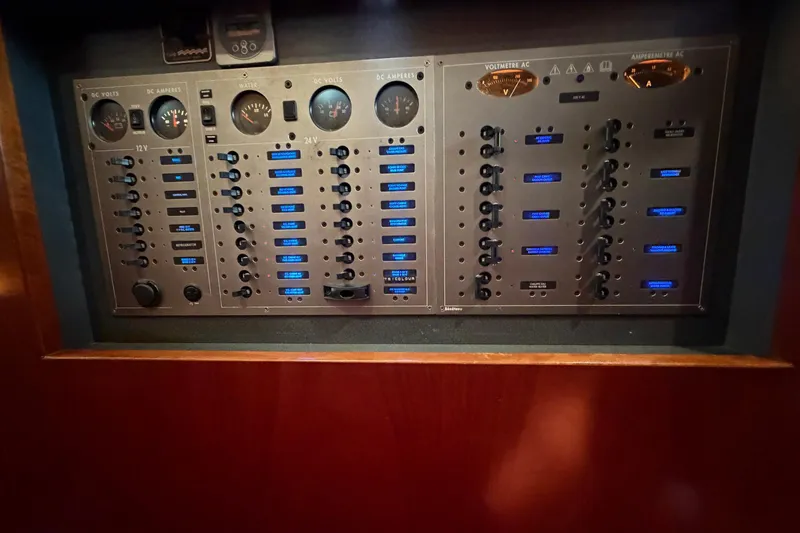 Slide: The Image of Electrical control panel on a 2004 Beneteau 57 yacht, featuring gauges and switches. - 83