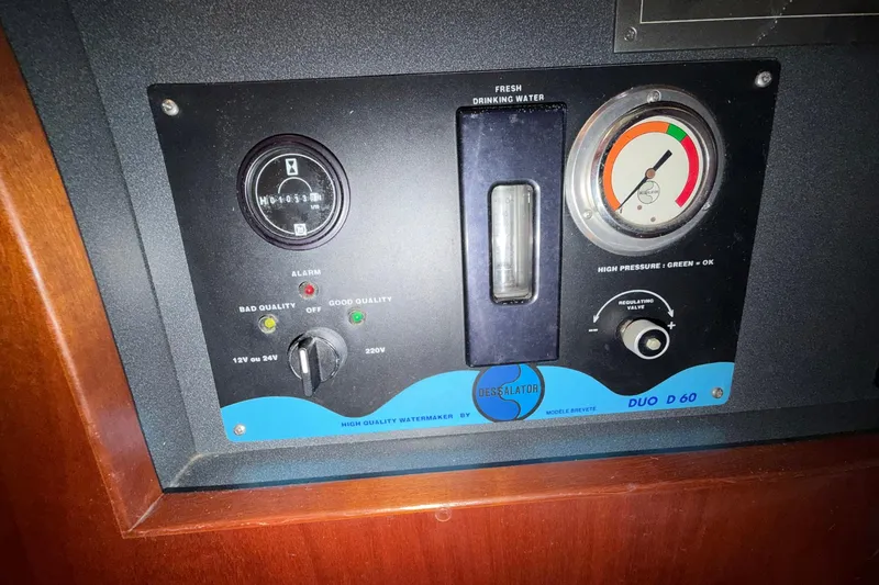 Slide: The Image of Control panel of a 2004 Beneteau 57 yacht, featuring watermaker gauges and indicators. - 85