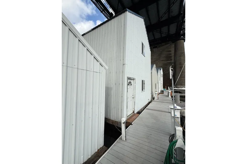 The Image of Marina dock with white buildings under a bridge, featuring a Grand Banks 42 Classic, 1981. - 0