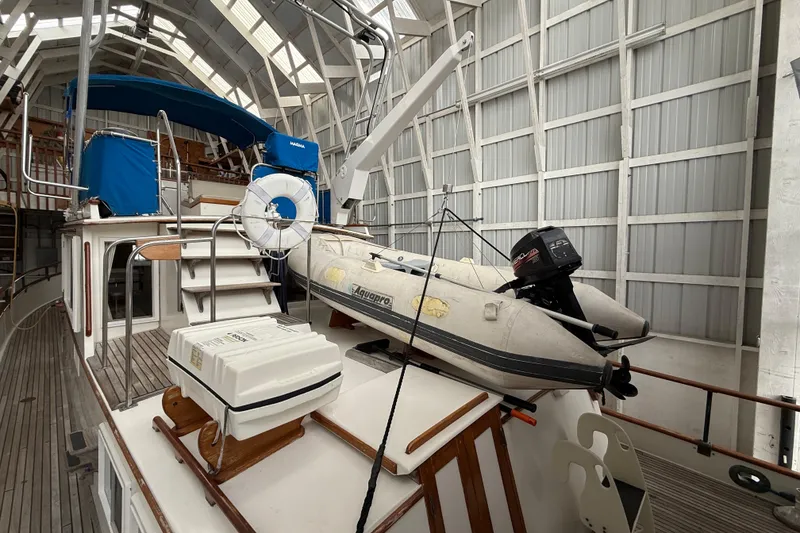 Slide: The Image of 1981 Grand Banks 42 Classic yacht with dinghy and outboard motor in covered storage. - 9