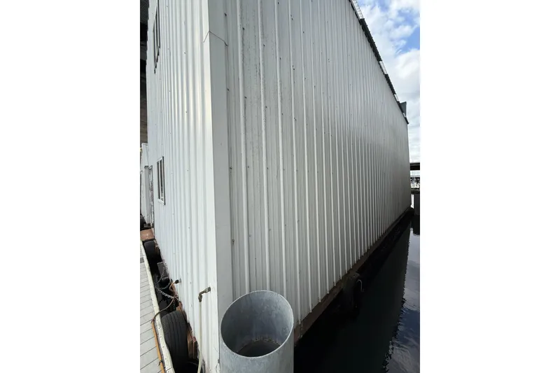 Slide: The Image of Side view of a docked Grand Banks 42 Classic boat, 1981 model, beside a metal structure. - 4