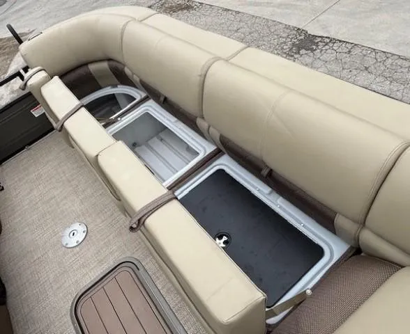 Slide: The Image of 2024 Regency 250 LE3 boat with open storage compartments and beige seating. - 13