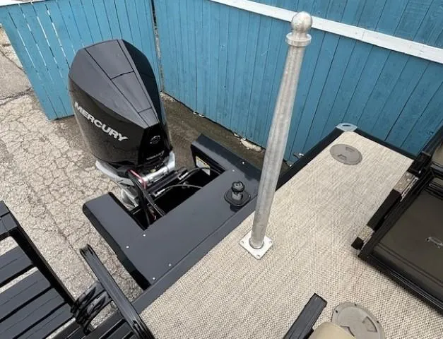 Slide: The Image of 2024 Regency 250 LE3 boat with Mercury outboard motor, docked near blue fence. - 44