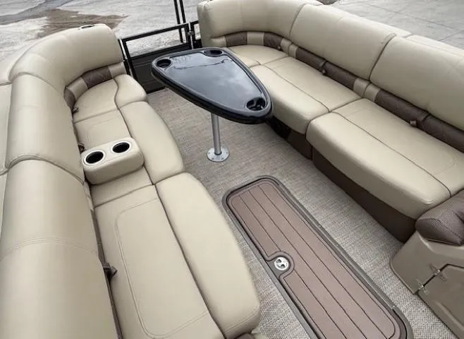 Slide: The Image of 2024 Regency 250 LE3 pontoon boat interior with beige seating and a central table. - 9