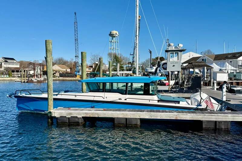 The Image of 2021 Axopar 37 XC CROSS CABIN docked at a marina under clear blue skies. - 1