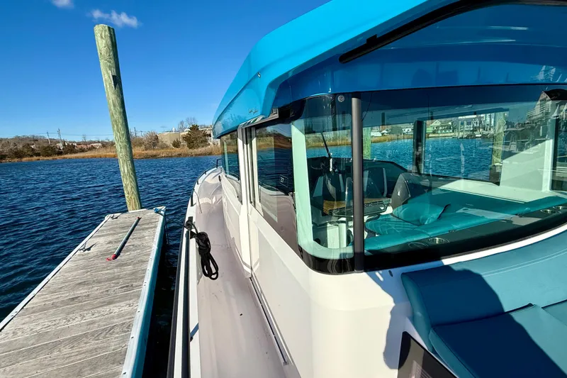 Slide: The Image of 2021 Axopar 37 XC CROSS CABIN docked on a sunny day, showcasing sleek design. - 11