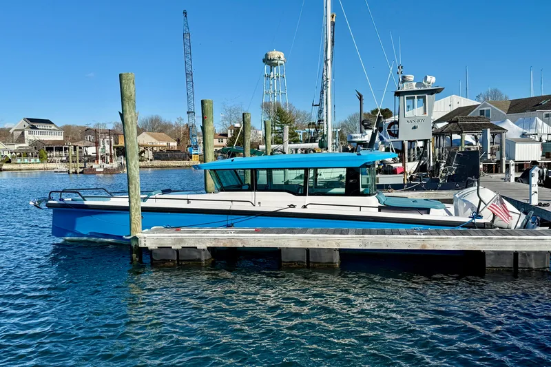 Slide: The Image of 2021 Axopar 37 XC CROSS CABIN docked at a marina under clear blue skies. - 12