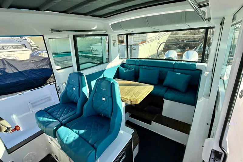 Slide: The Image of Interior of 2021 Axopar 37 XC CROSS CABIN with teal seating and wooden table. - 13