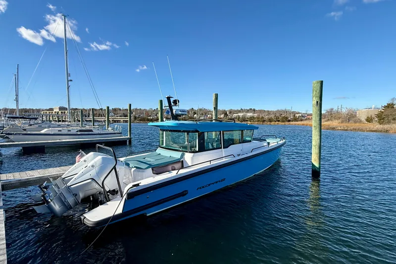 Slide: The Image of 2021 Axopar 37 XC CROSS CABIN boat docked in a marina under clear blue skies. - 3