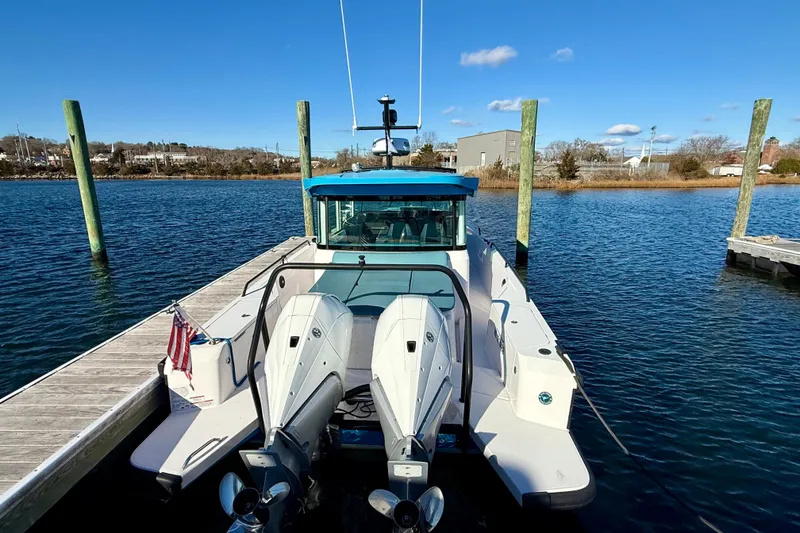 Slide: The Image of 2021 Axopar 37 XC CROSS CABIN docked, featuring dual outboard motors and sleek design. - 4
