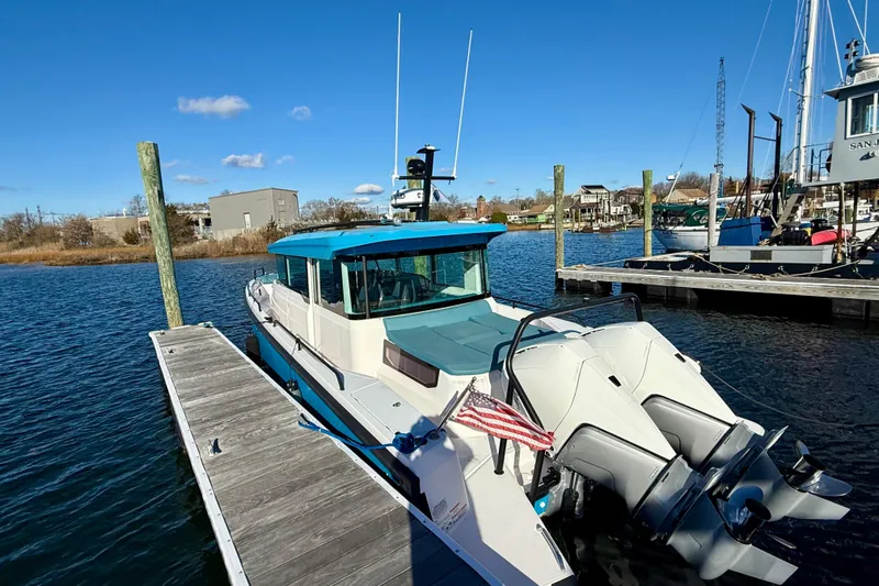 Slide: The Image of 2021 Axopar 37 XC CROSS CABIN docked at marina under clear blue sky. - 5