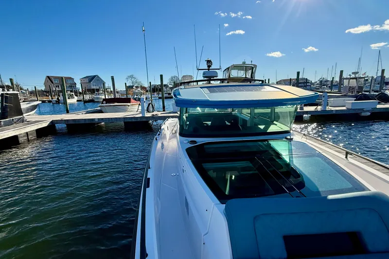 Slide: The Image of 2021 Axopar 37 XC CROSS CABIN docked at a marina under clear blue skies. - 8