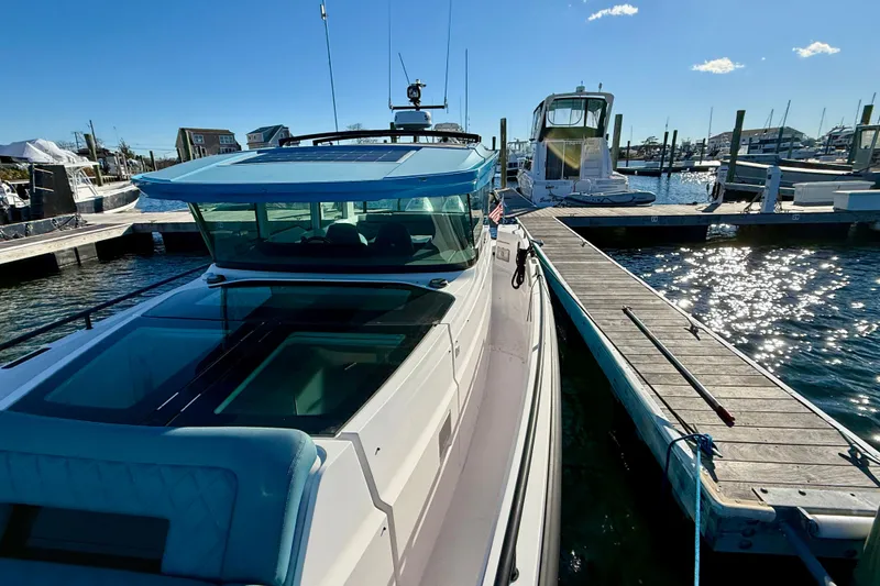 Slide: The Image of 2021 Axopar 37 XC CROSS CABIN docked at marina under clear blue sky. - 9
