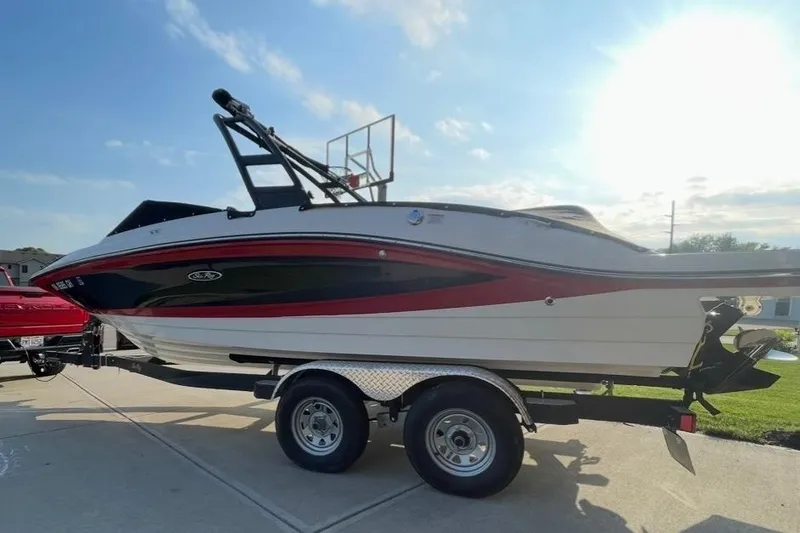 The Image of 2022 Sea Ray SPX 210 boat on trailer, parked outdoors in sunlight. - 0