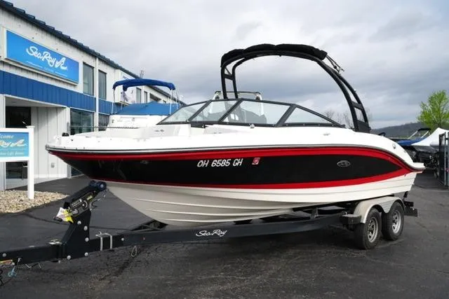 The Image of 2022 Sea Ray SPX 210 boat on trailer, displayed outside dealership. - 12