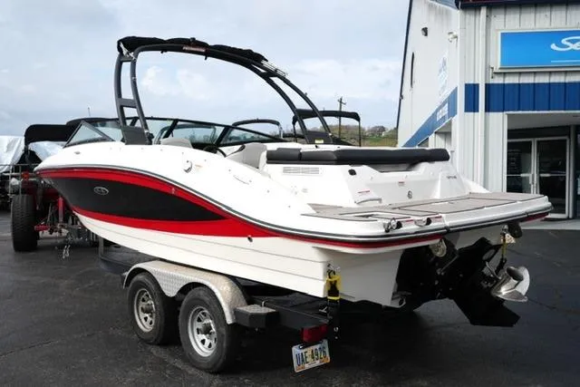 Slide: The Image of 2022 Sea Ray SPX 210 boat on trailer, white with red accents, parked outside dealership. - 17