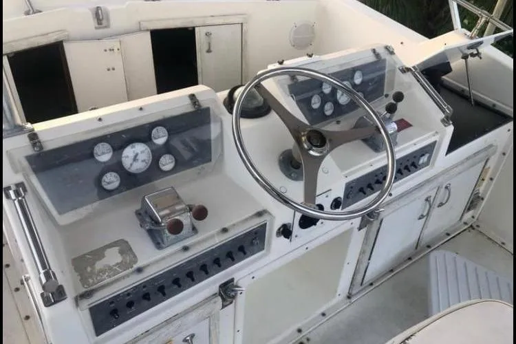 Slide: The Image of 1985 Hatteras 36 Convertible boat helm with steering wheel and control panels. - 2