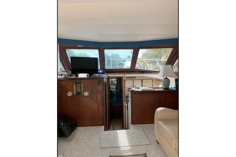Slide: The Image of Interior of 1985 Hatteras 36 Convertible yacht with wood paneling and windows. - 7
