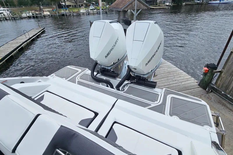 Slide: The Image of 2026 Monterey Elite 30 OB boat with dual Mercury outboard engines docked by a lakeside. - 28