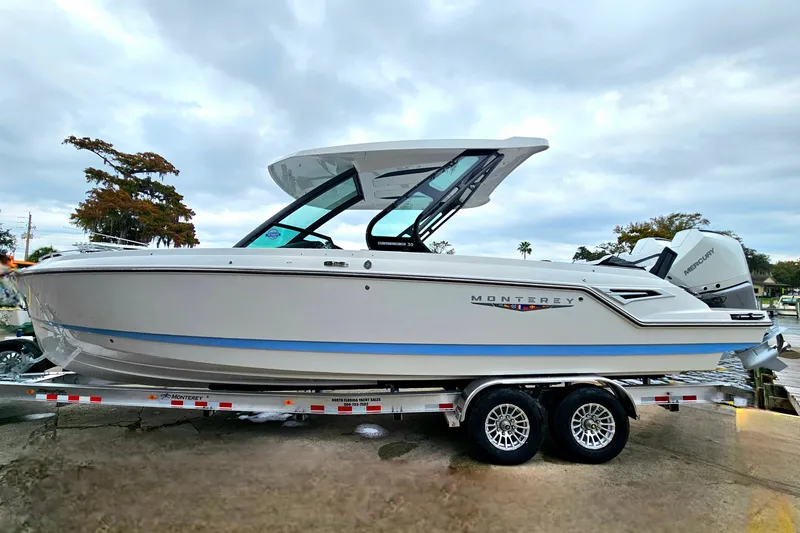 Slide: The Image of 2026 Monterey Elite 30 OB boat on trailer, sleek design, overcast sky background. - 3