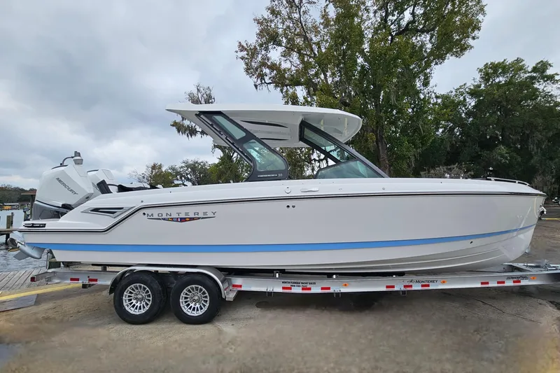 Slide: The Image of 2026 Monterey Elite 30 OB boat on trailer, sleek design, parked outdoors. - 4