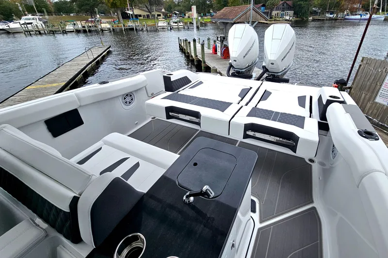 Slide: The Image of 2026 Monterey Elite 30 OB boat interior with dual outboard motors, docked by a scenic waterfront. - 7