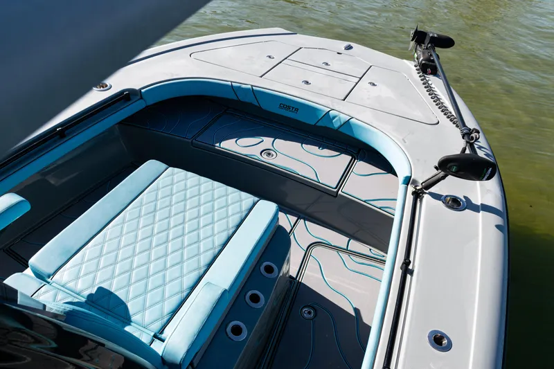 Slide: The Image of 2022 Costa Custom Boats 264 interior with blue seating and sleek design on water. - 11