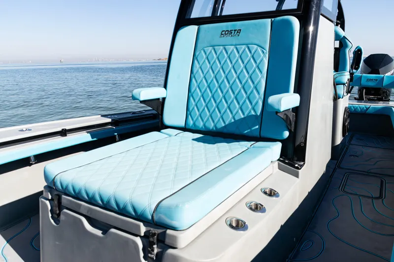 Slide: The Image of Luxurious seating on 2022 Costa Custom Boats 264, featuring blue diamond-stitched upholstery. - 13