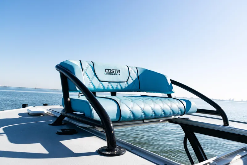 Slide: The Image of 2022 Costa Custom Boats 264 with blue seating, ocean backdrop. - 20