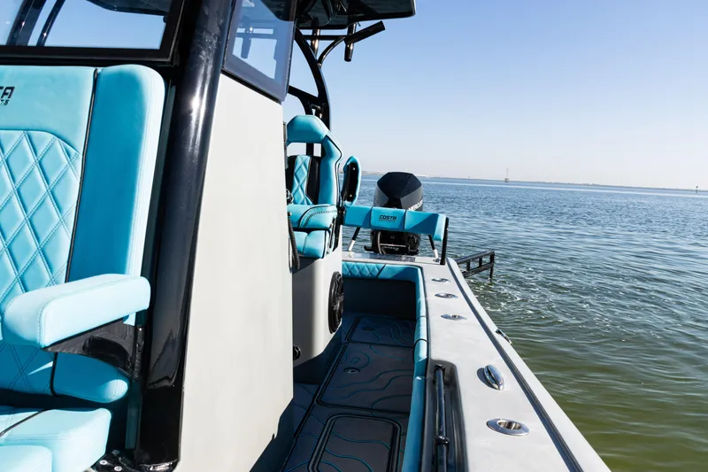 Slide: The Image of 2022 Costa Custom Boats 264 on water, featuring sleek design and turquoise seating. - 21