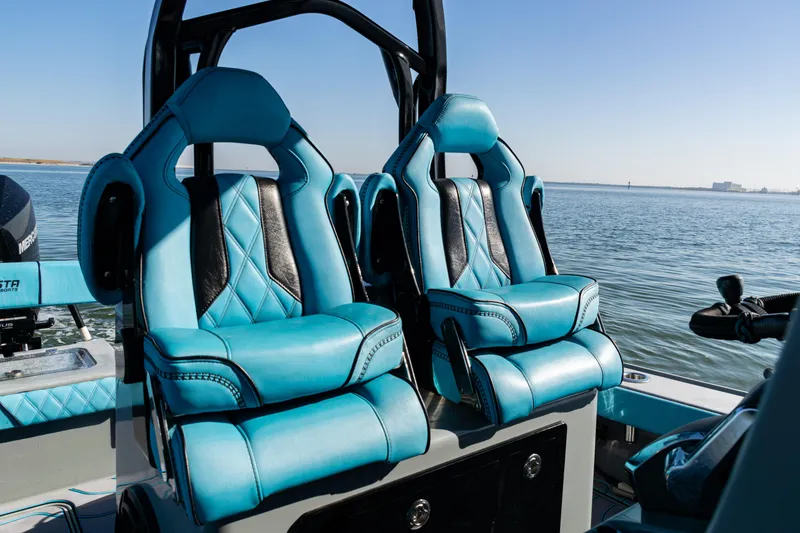 Slide: The Image of Luxurious blue seats on a 2022 Costa Custom Boats 264, overlooking serene waters. - 23