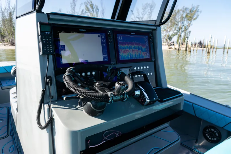 Slide: The Image of Control panel of 2022 Costa Custom Boats 264 with navigation screens and steering wheel. - 25