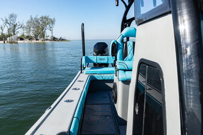 Slide: The Image of 2022 Costa Custom Boats 264 on calm water, featuring sleek design and vibrant seating. - 28