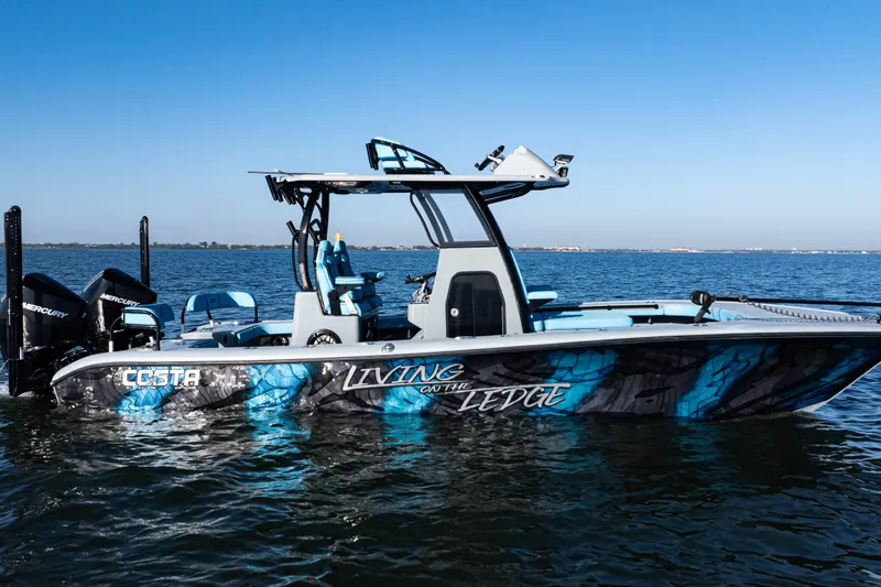 Slide: The Image of 2022 Costa Custom Boats 264 on water, vibrant blue design, twin Mercury engines. - 3