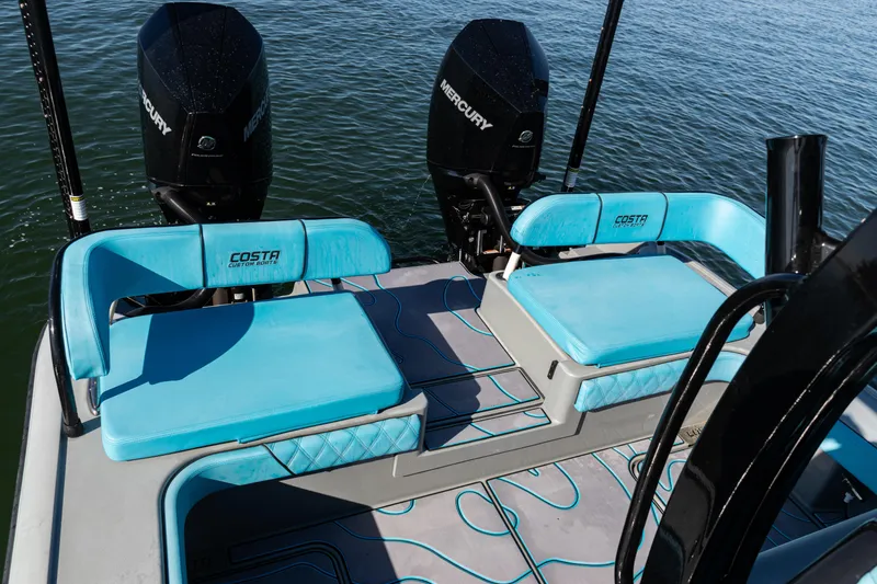 Slide: The Image of 2022 Costa Custom Boats 264 with twin Mercury engines and blue seating on the water. - 31